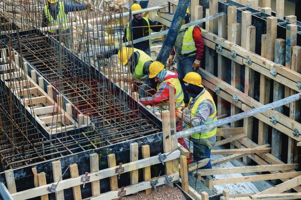 Construction crew building reinforced concrete formwork