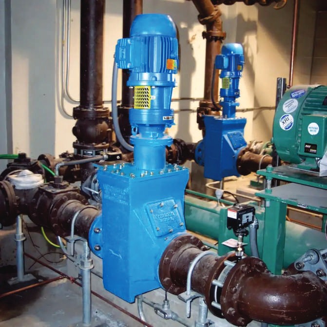 Blue industrial pump assemblies installed in a plant room